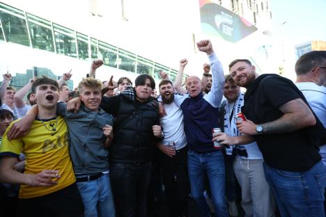 Group of excited Tottenham Hotspur fans outside the stadium.