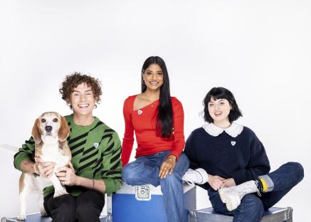 Photo of three Blue Peter presenters and a dog.