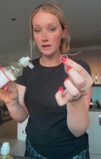 Woman holding a bottle of fruit drink and a small plastic ring, warning about choking hazard.