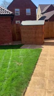 Backyard of a council house with a wooden shed.
