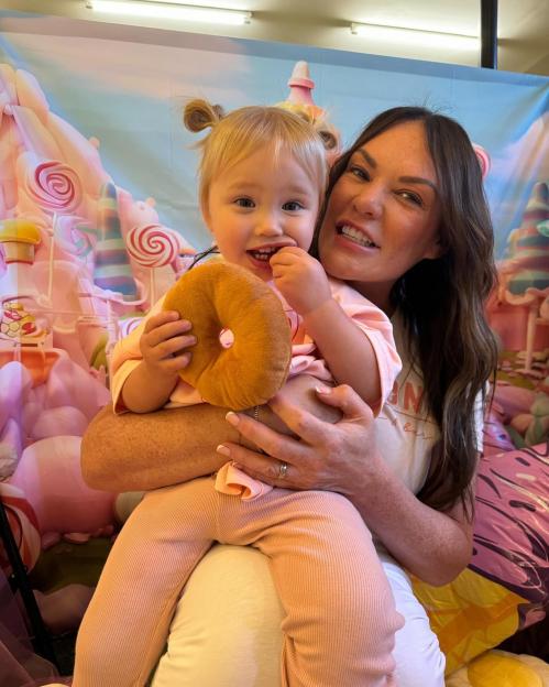 Charlotte Crosby holding her daughter Alba, who is holding a toy donut, at her second birthday party.