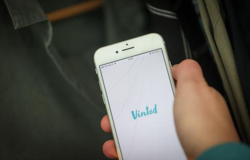 a person is holding a phone that says vinted on the screen
