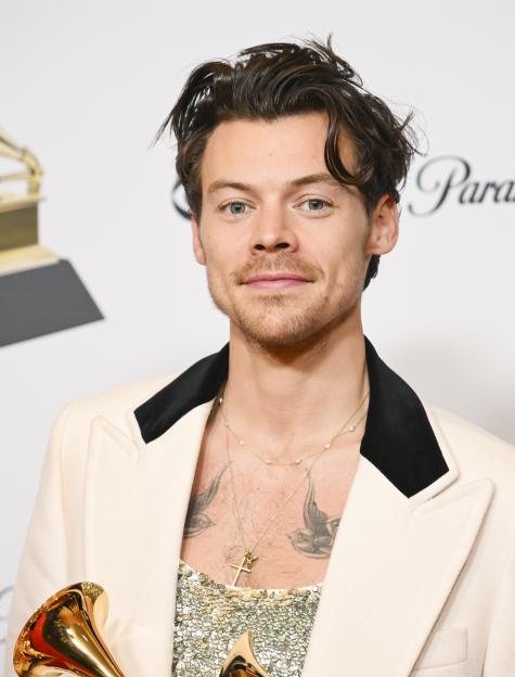 Harry Styles holding his Grammy Awards.