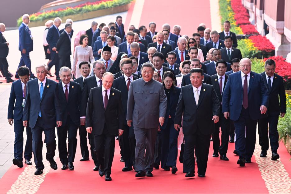 Xi Jinping, Vladimir Putin, and Kim Jong Un walking with other world leaders.