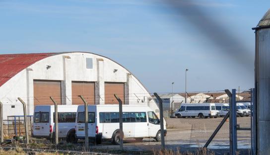 White vans parked outside a warehouse.