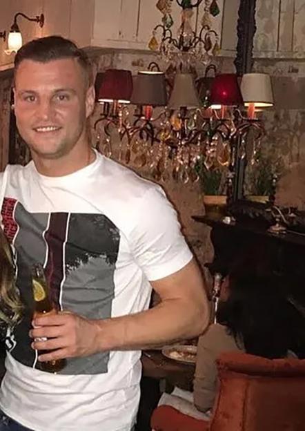 Man holding a beer in a restaurant.