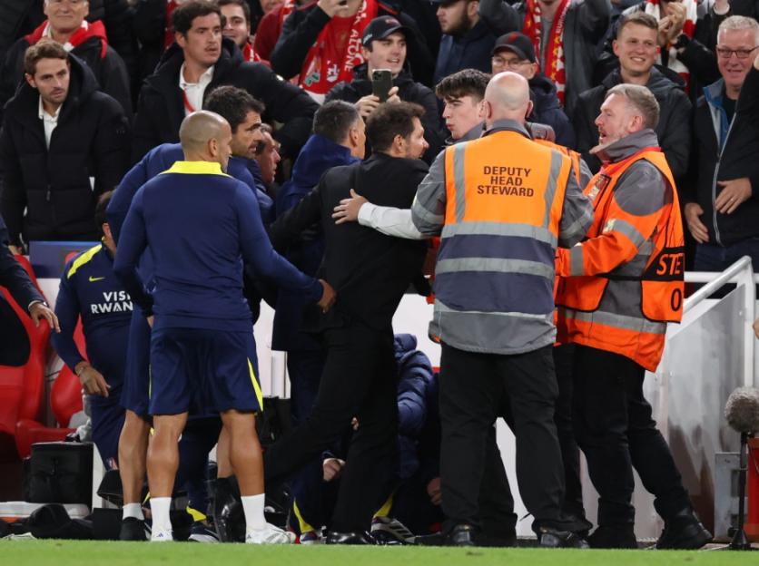 A group of people, including security personnel, involved in a scuffle on the sidelines during the UEFA Champions League match between Liverpool FC and Atletico de Madrid.