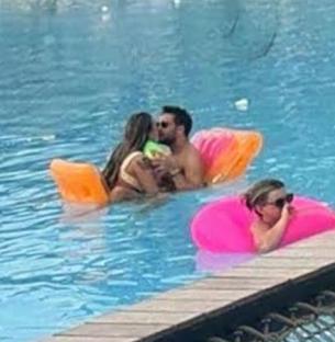 Jojo Siwa and Chris Hughes kissing in a pool.