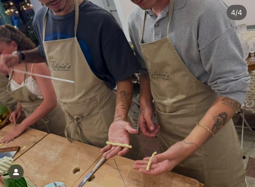Two people making pasta in a cooking class.