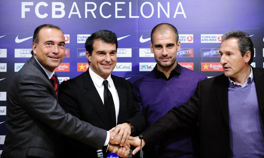 Four men from Barcelona Football Club including coach Pep Guardiola, president Joan Laporta, and vice president Rafael Yuste shake hands during a press conference.