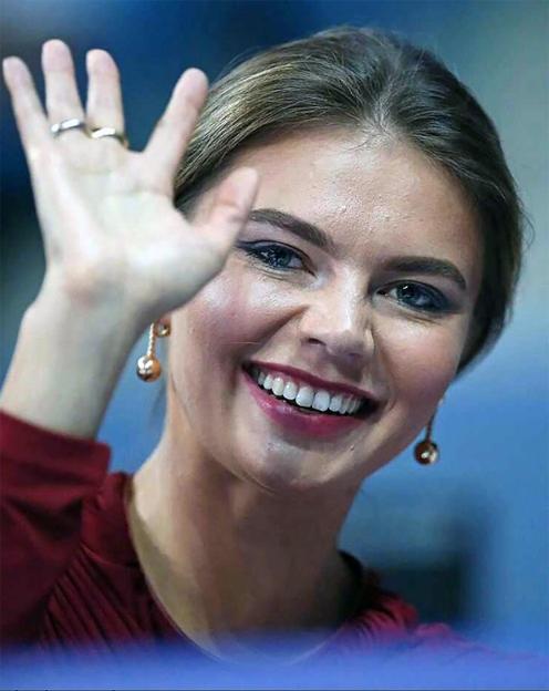 Close-up of Alina Kabaeva waving, showing rings on her fingers.