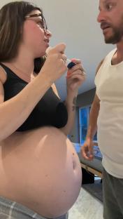 Pregnant woman and man looking at a pregnancy test.