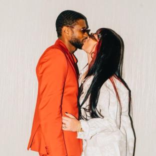 Usher and Jenn Goicoechea kissing.