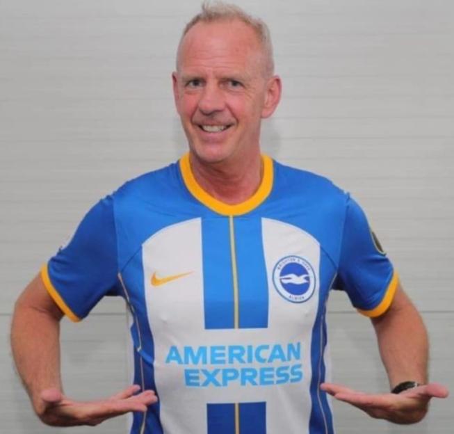 Fatboy Slim wearing a Brighton & Hove Albion football shirt.