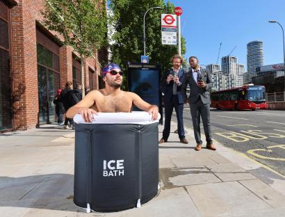 Man taking an ice bath at a bus stop.