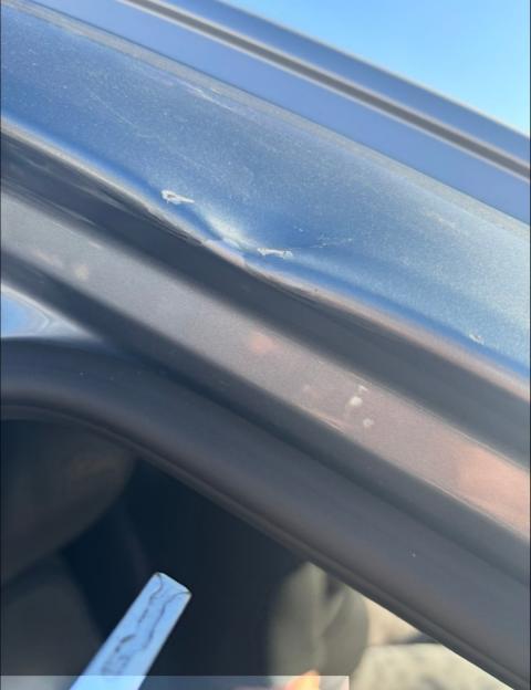 Damaged car door showing scratches and dents.