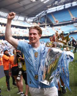 Kevin De Bruyne of Manchester City celebrating with the Premier League trophy.