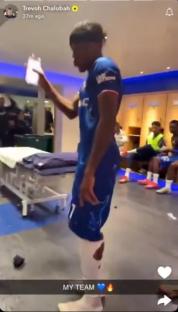 Soccer player in a team uniform in a locker room.
