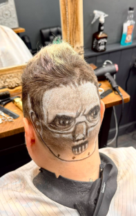Hair with a shaved design of a face on the back of the head.