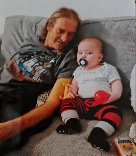 A father and his baby on a couch.