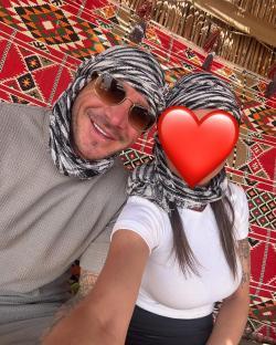 Couple wearing patterned headscarves; woman's face is obscured.
