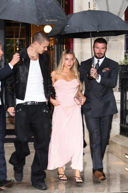 David Beckham and his daughter Harper Beckham, with his son Romeo Beckham holding an umbrella, leaving La Reserve hotel.