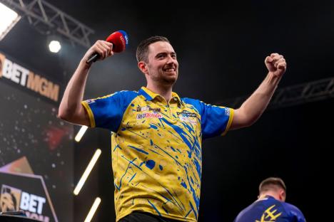 Luke Humphries celebrates a darts victory.