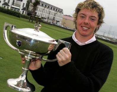 Rory McIlroy holding a trophy after winning a golf championship.