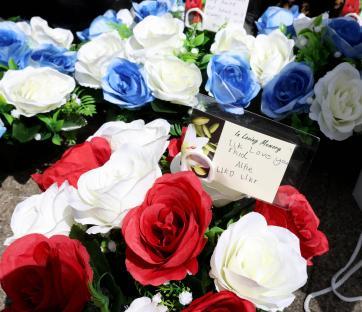 Floral tributes with a handwritten message.