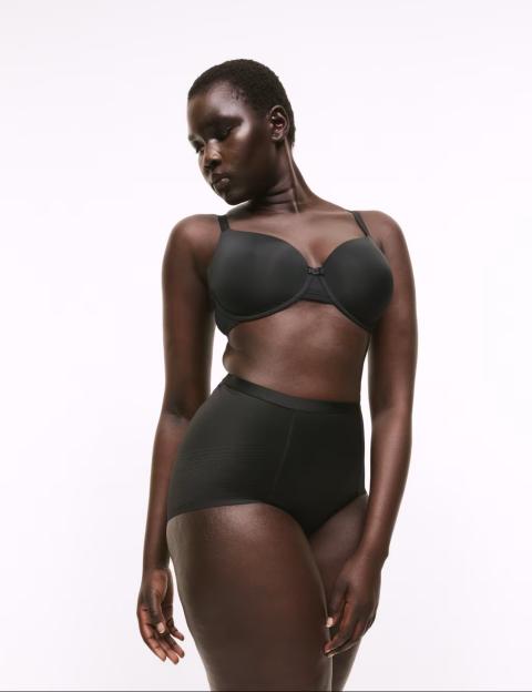 Model wearing black bra and high-waisted briefs.