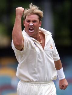 Shane Warne celebrating a cricket wicket.