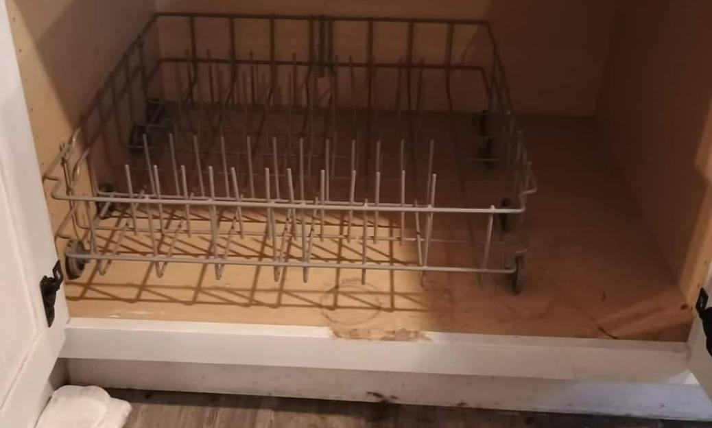 Empty dishwasher rack in cabinet.