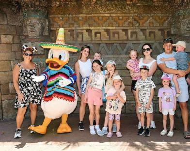 Family posing with Donald Duck in a Mexican costume.