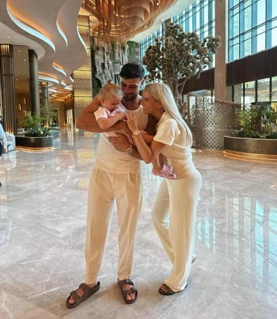 Molly-Mae Hague, her partner, and their baby in matching cream outfits.