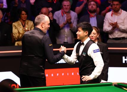 Xintong Zhao and Mark Williams shaking hands after a snooker match.