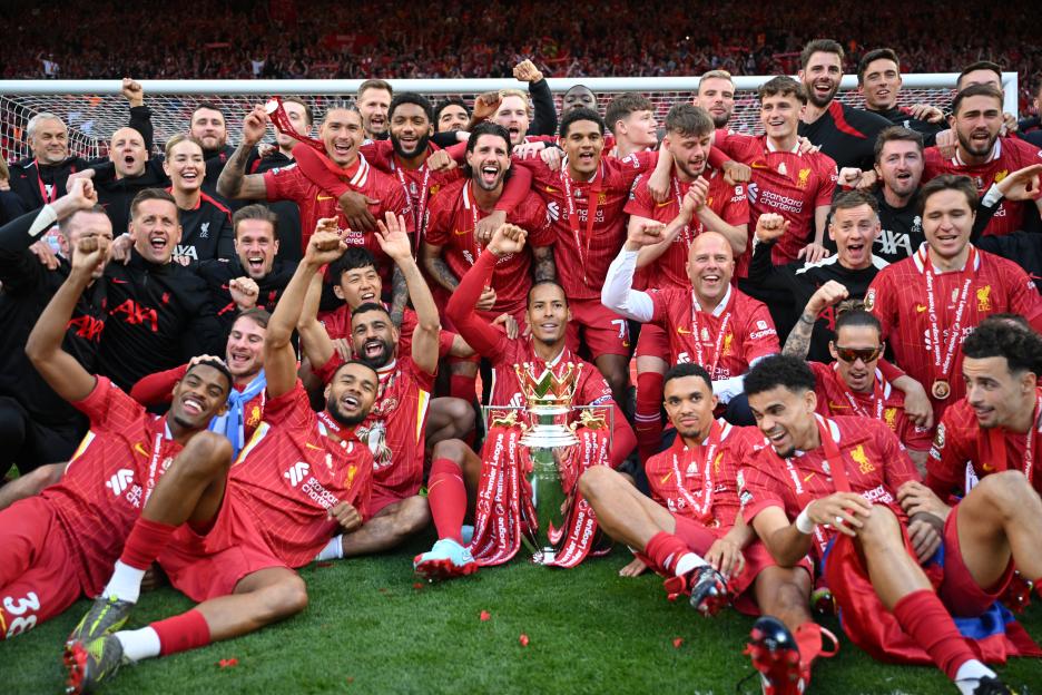 Liverpool players celebrating Premier League victory with trophy.