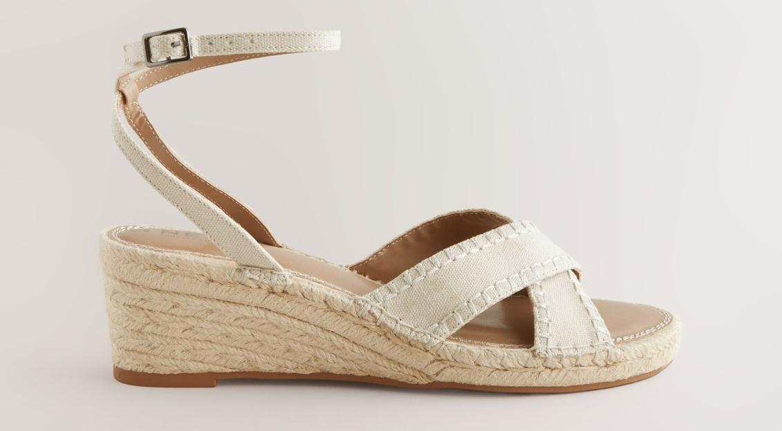 Off-white espadrille wedge sandals with ankle strap.