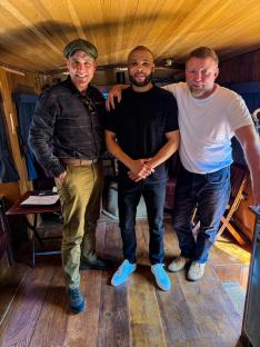 Chris Eubank Jr. with two other men on the set of a Netflix show.