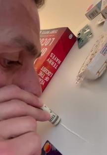 Person snorting cocaine using a rolled-up dollar bill.