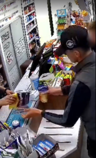 Surveillance image of a person purchasing items at a store counter.