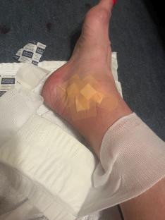 Woman's foot with bandages on a small cut.