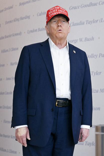 Donald Trump wearing a red hat that says "Trump Was Right About Everything".