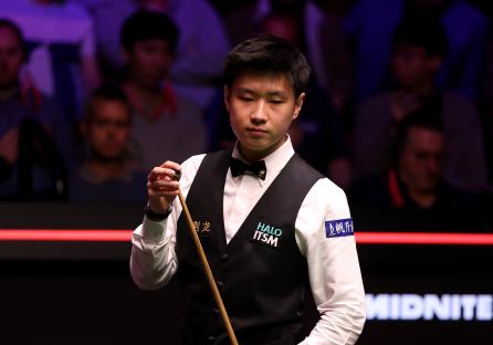 Zhao Xintong of China preparing for a snooker shot.