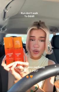 Woman holding two bottles of B&M fragrance mist, a Sol de Janeiro dupe.