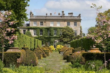 Highgrove House gardens with topiary and a large house in the background.