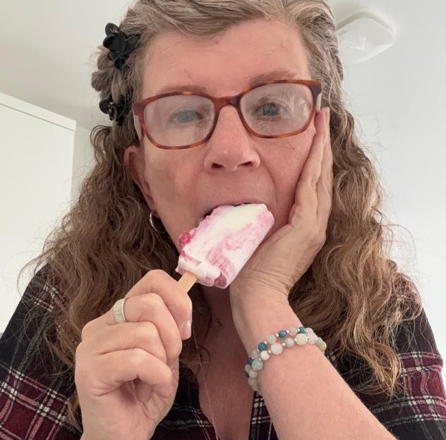 Lesley Thomas eating a red and white popsicle.