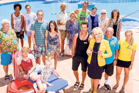 Group photo of people by a swimming pool.