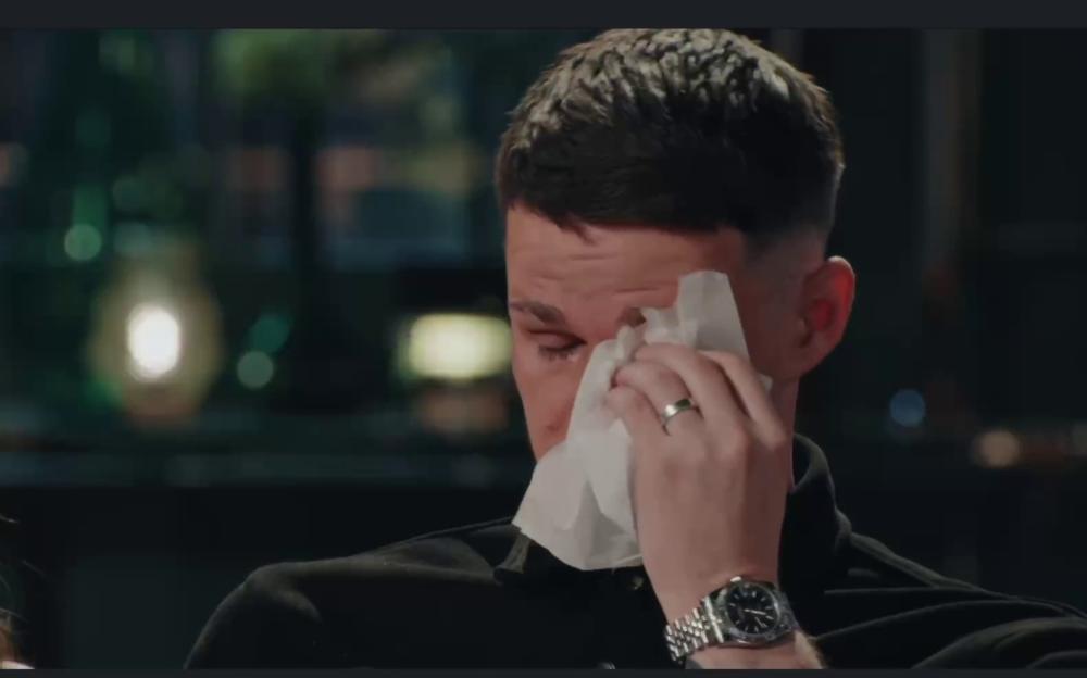 A man wiping his eyes with a tissue.