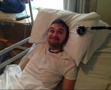 Man smiling in a hospital bed.