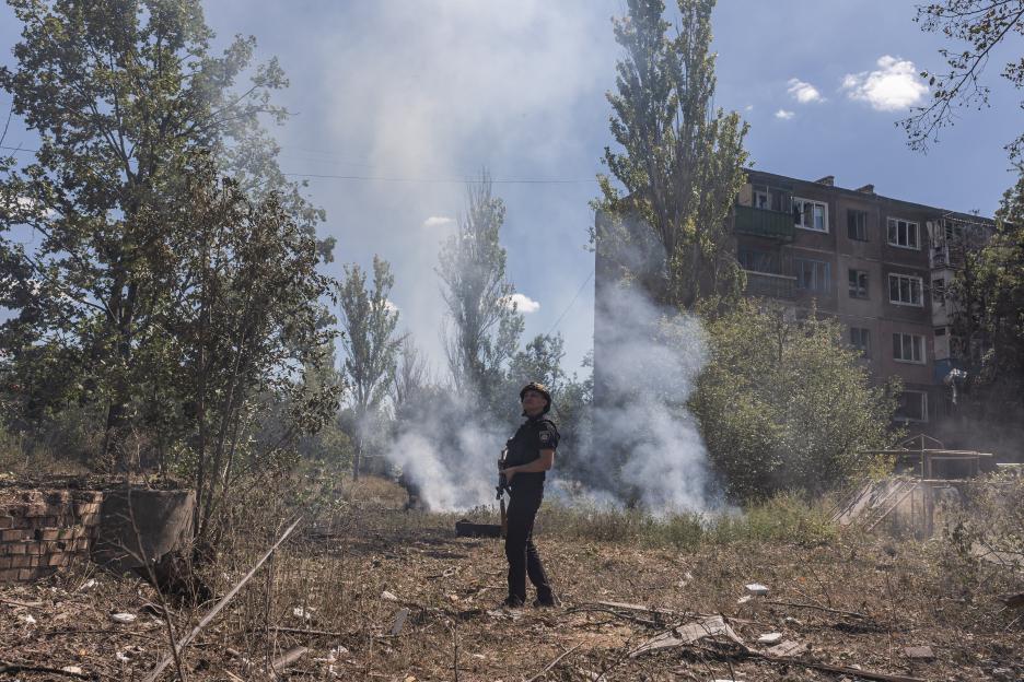 Ukrainian firefighter amidst smoke and debris after a Russian airstrike.